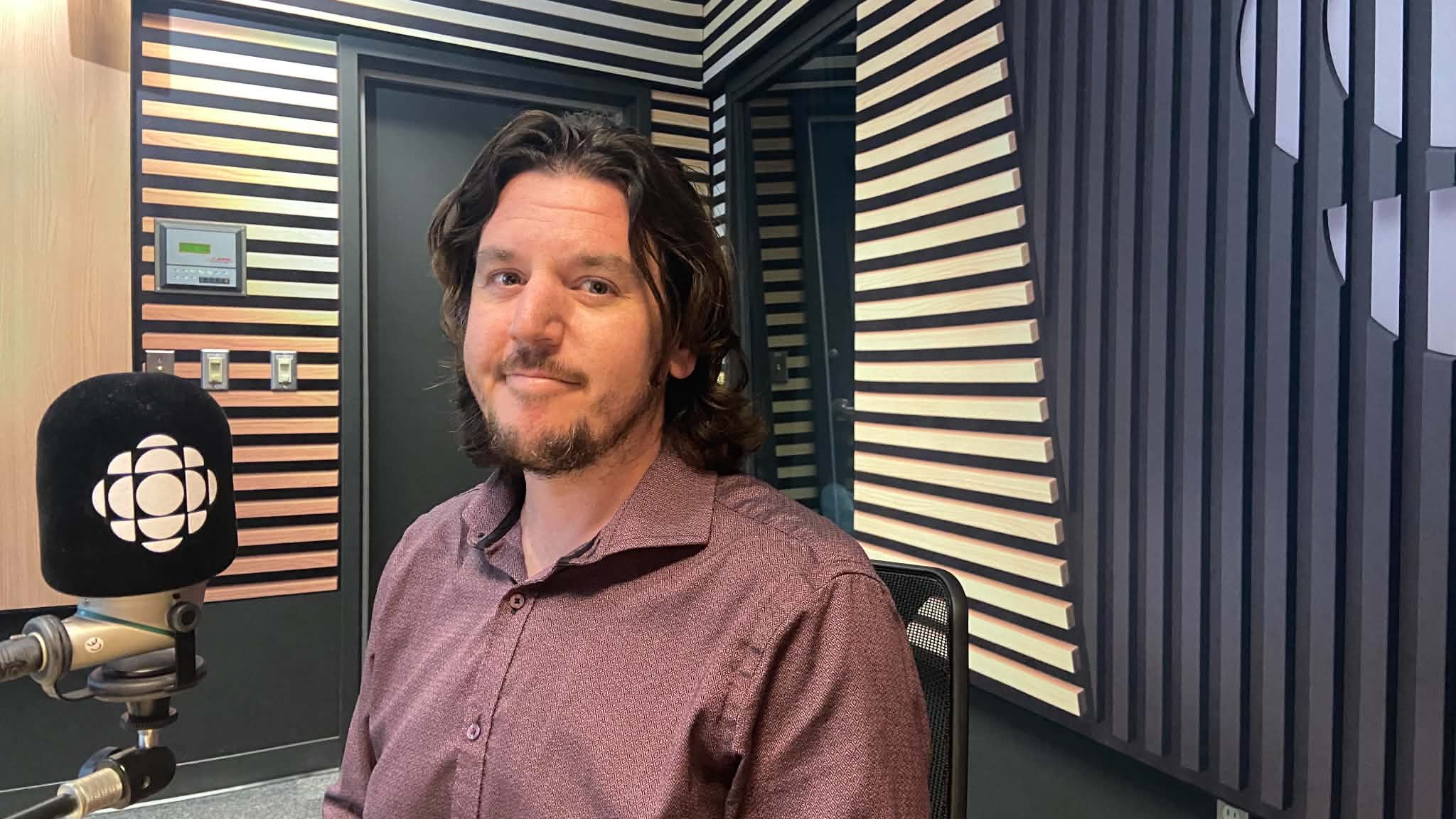 Alex Pigeon seated beside a Radio-Canada microphone in the Sur le vif studio.